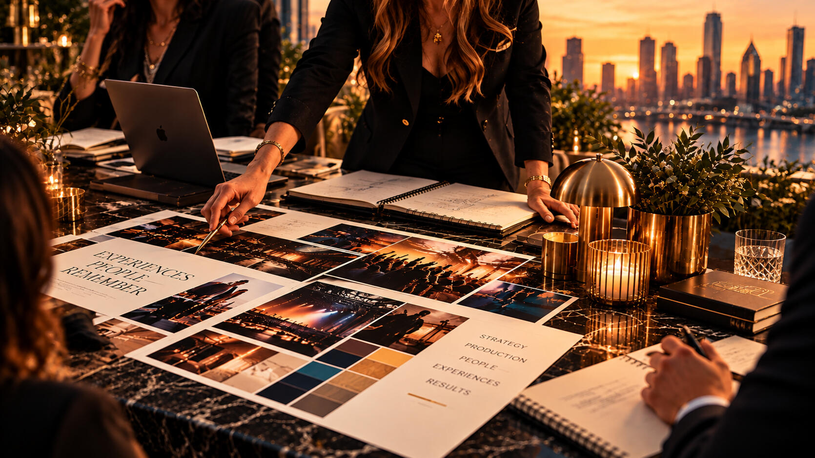 Event planning team reviewing photographs, creative concepts, and production materials around a conference table.